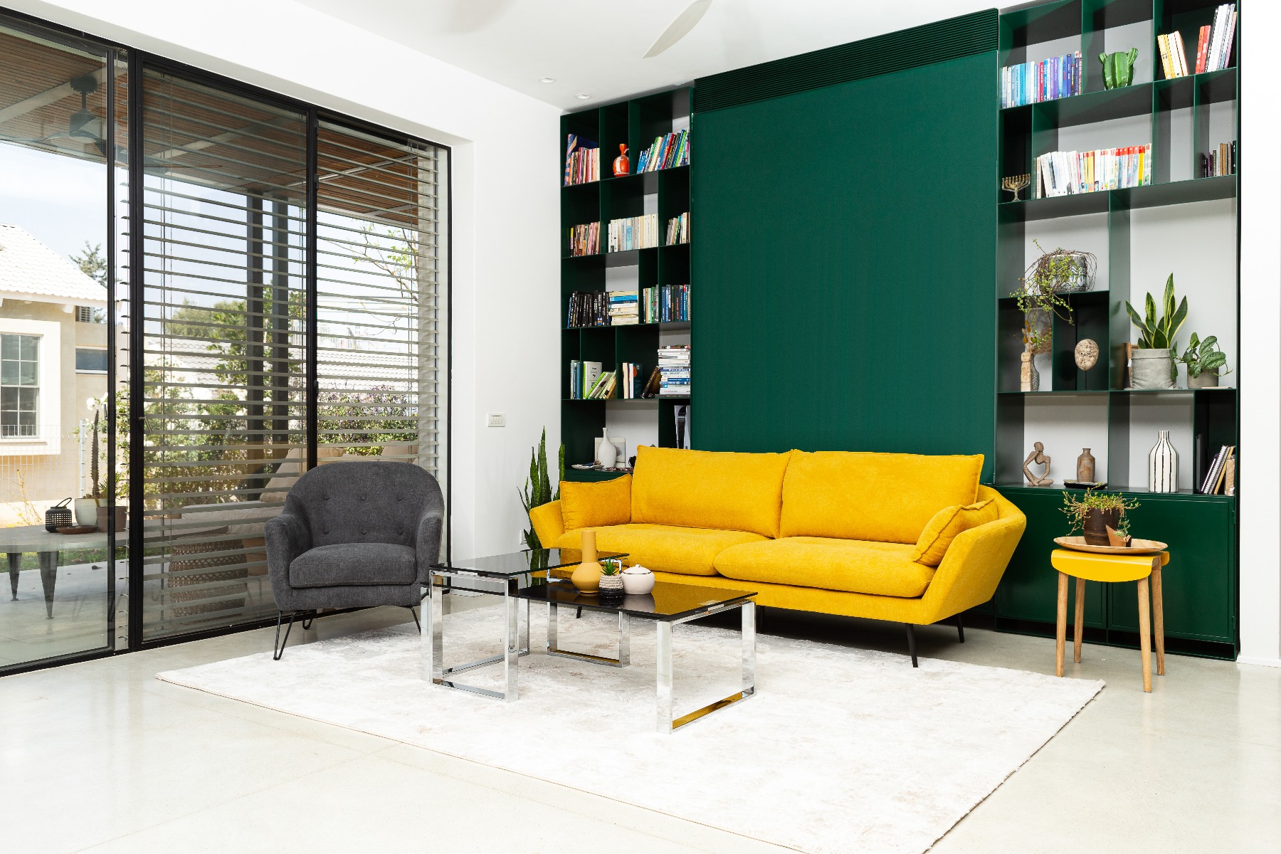 ספת CHILL  VIBE אפורה ויפה תלת מושבית בצבע צהוב בחדר מעוצב עם קיר ירוק ושטיח בצבע בז' וכורסת